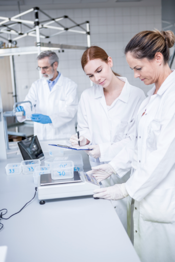 Zwei Laborantinnen dokumentieren Messergebnisse an einer Analysenwaage