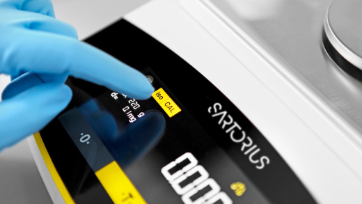 Präzise Juwelierwaage mit digitaler Anzeige auf einem Arbeitstisch in einem Schmuckatelier.