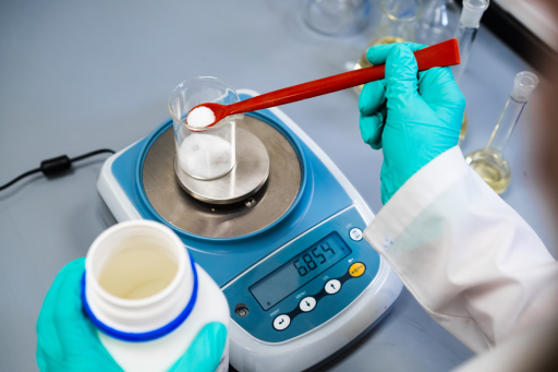 Chemist weighs powder samples with a laboratory balance